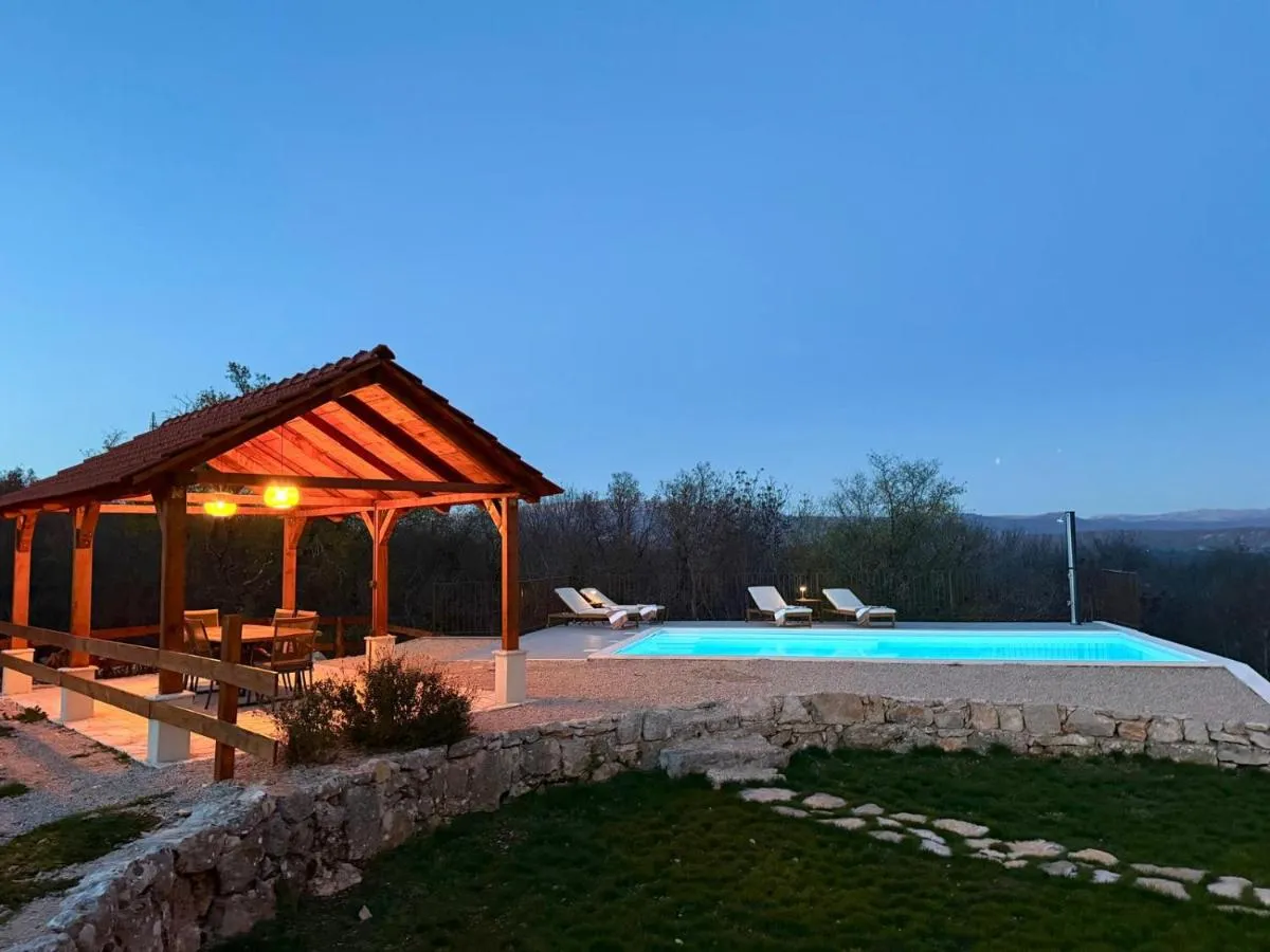 Covered terrace and private heated pool at Villa Billubium at dusk