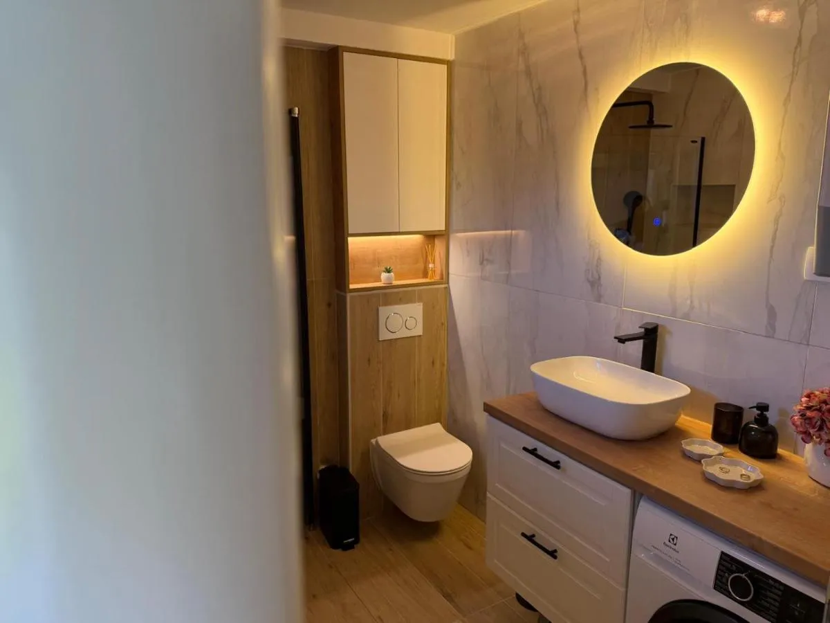 Bathroom vanity with a round illuminated mirror