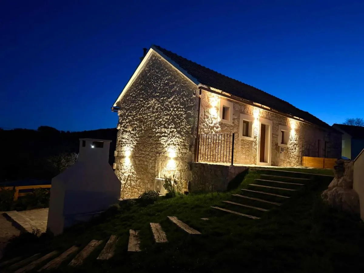 Illuminated stone facade of Villa Billubium in the evening