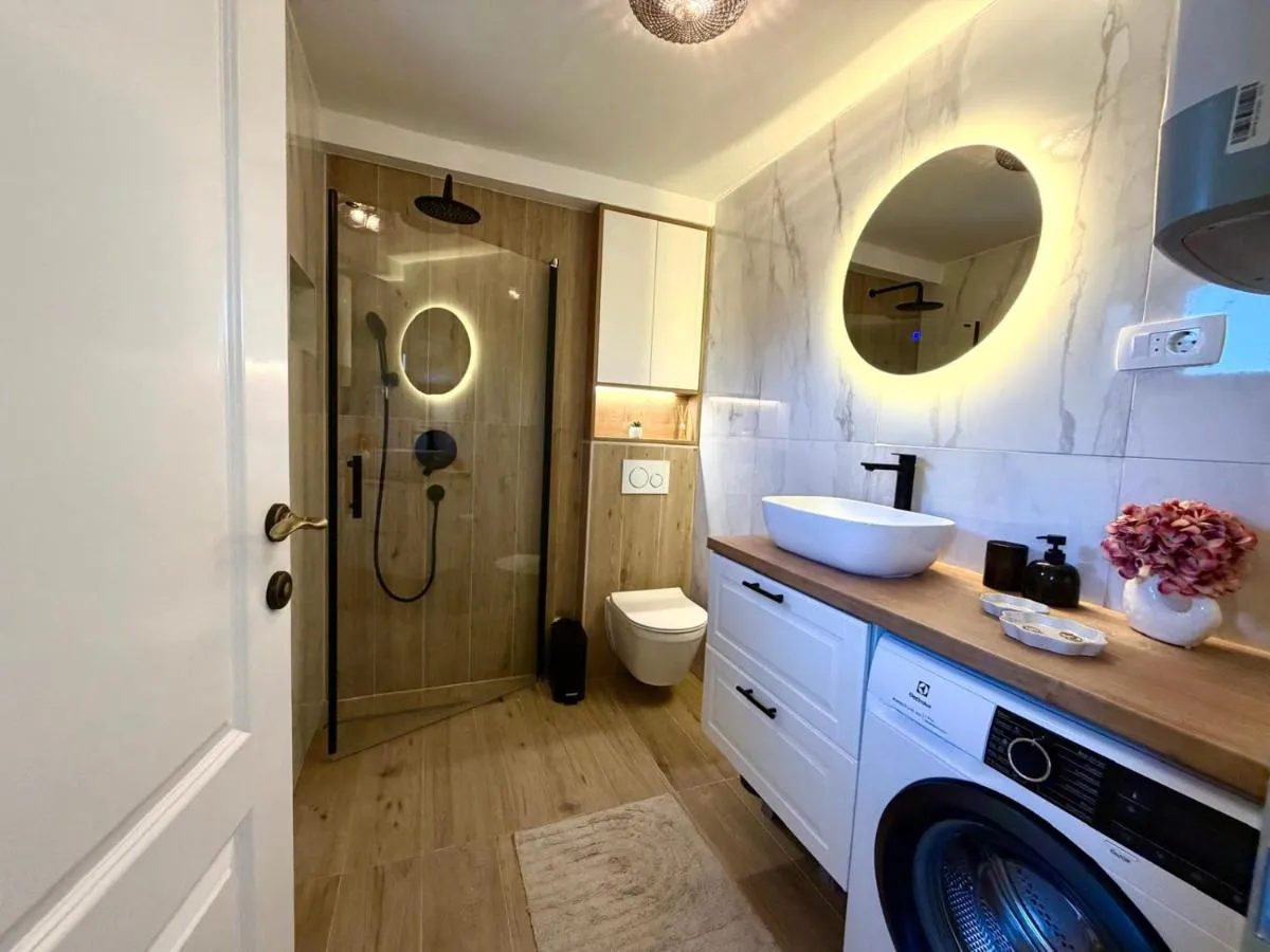 Modern bathroom with walk-in shower and washing machine
