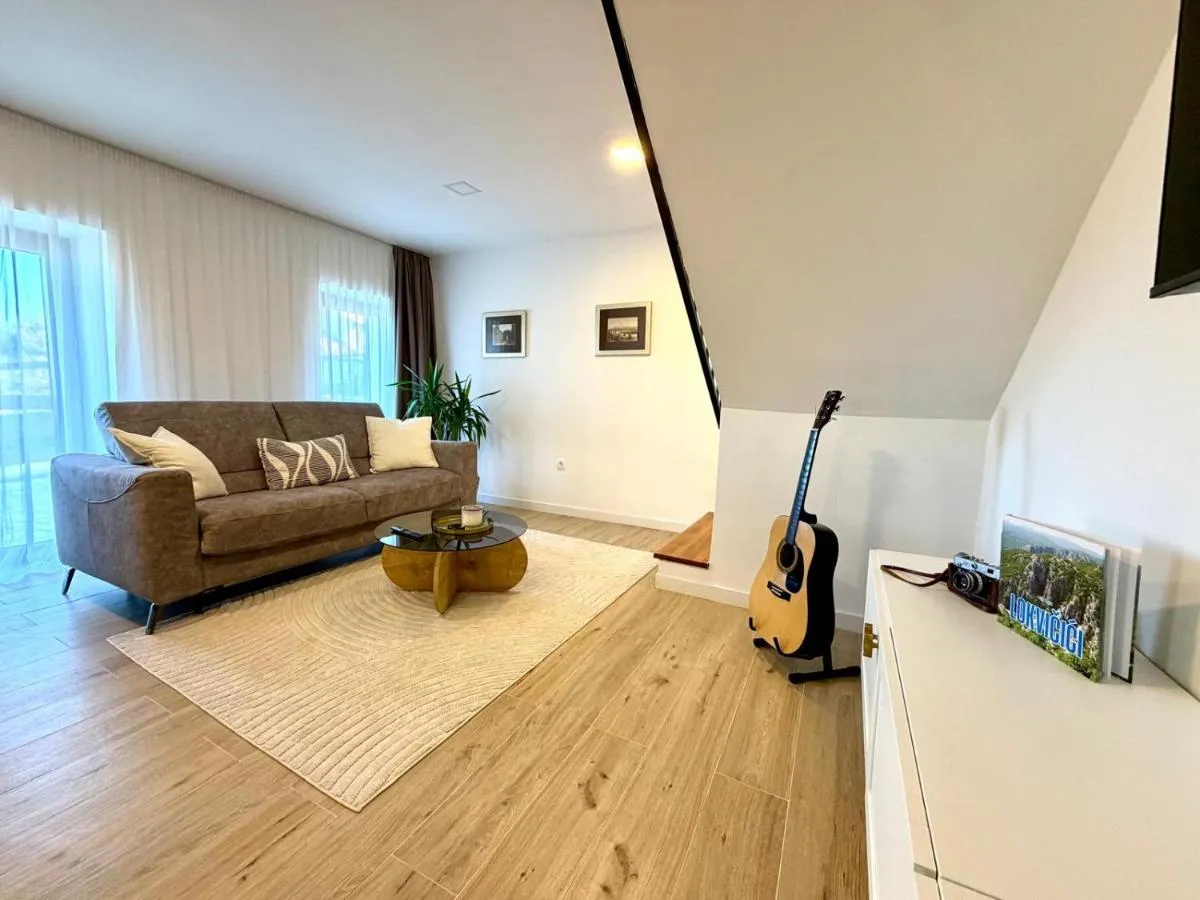 Bright lounge area with sofa and guitar