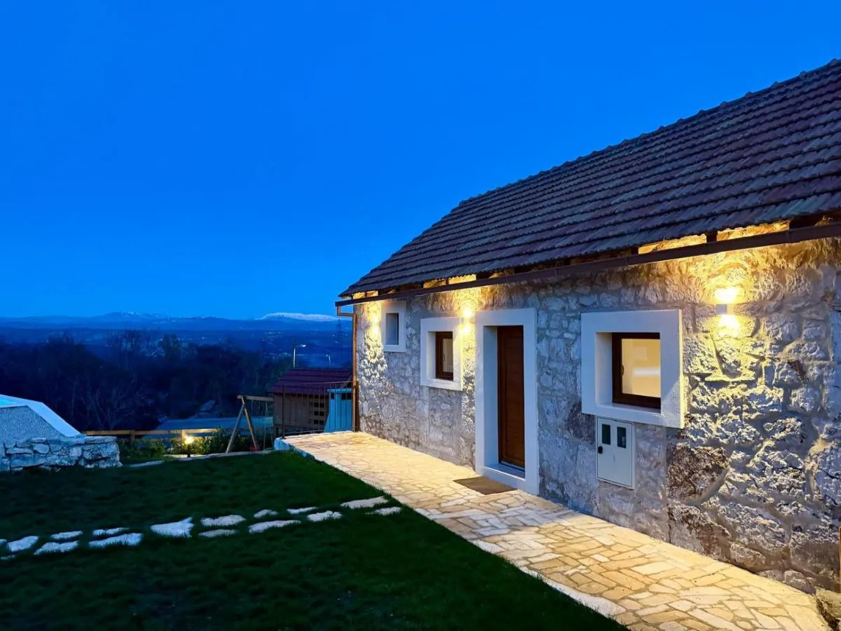 Warm evening lights across the stone facade of the villa