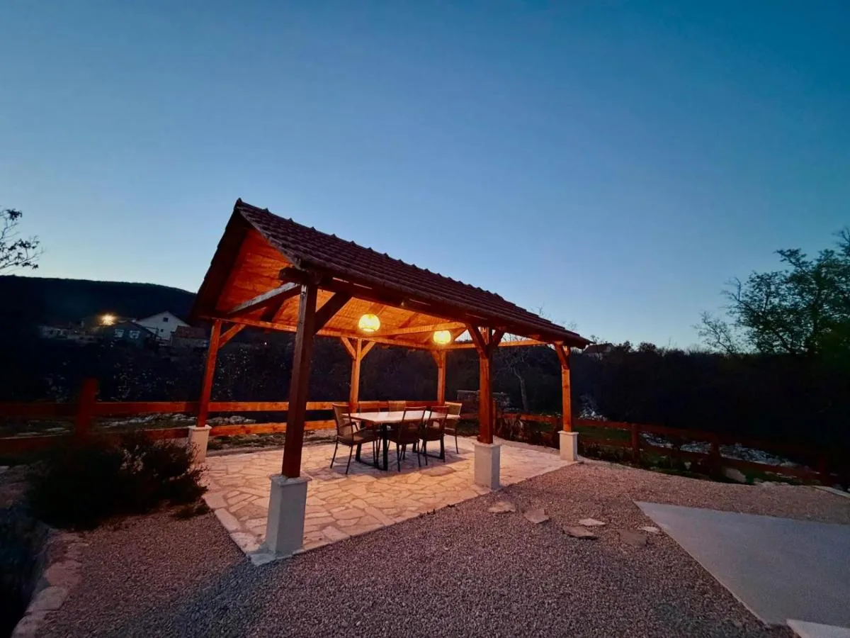 Covered wooden outdoor dining terrace illuminated at night